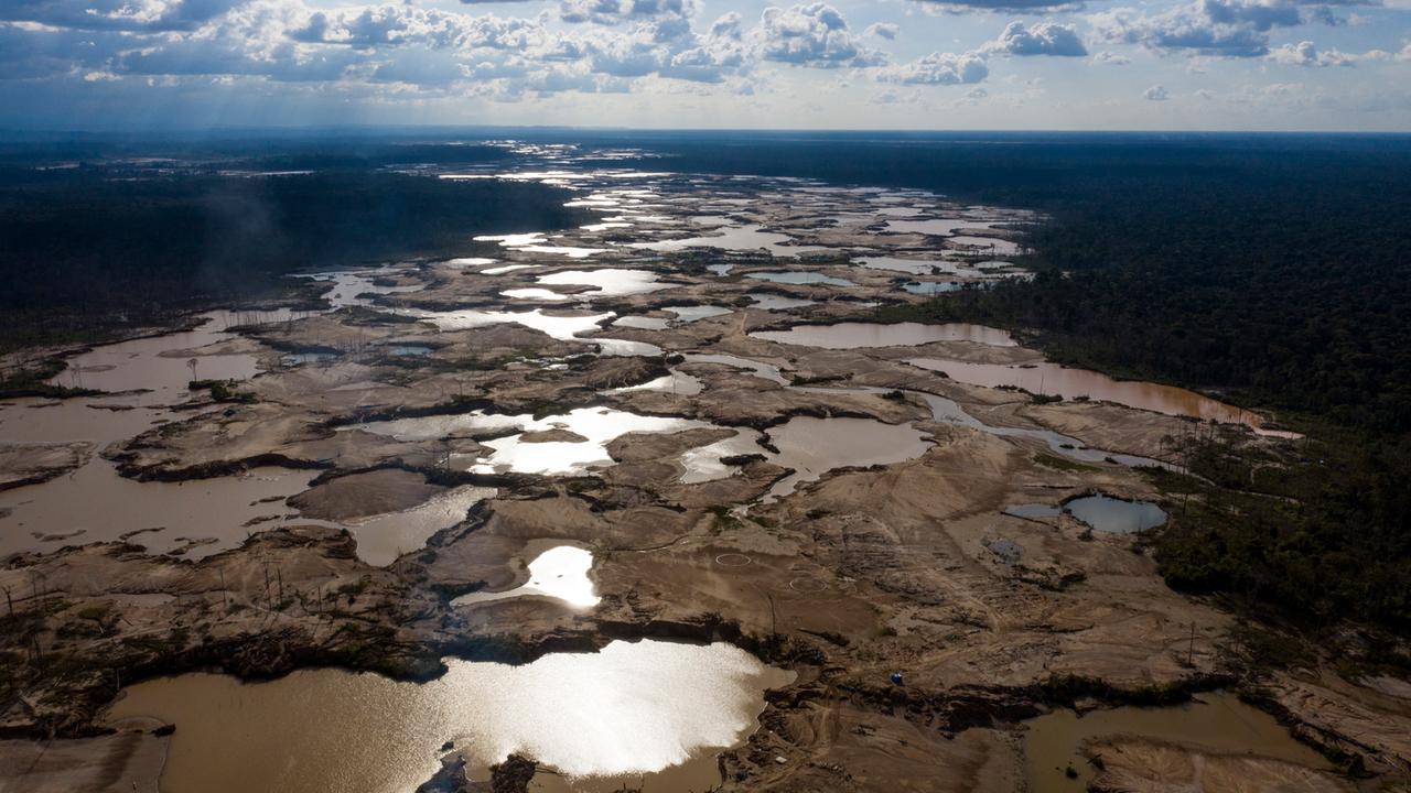 Luftaufnahme einer großen Fläche aus Schlamm, die sich im Amazonasregenwald ausbreitet.