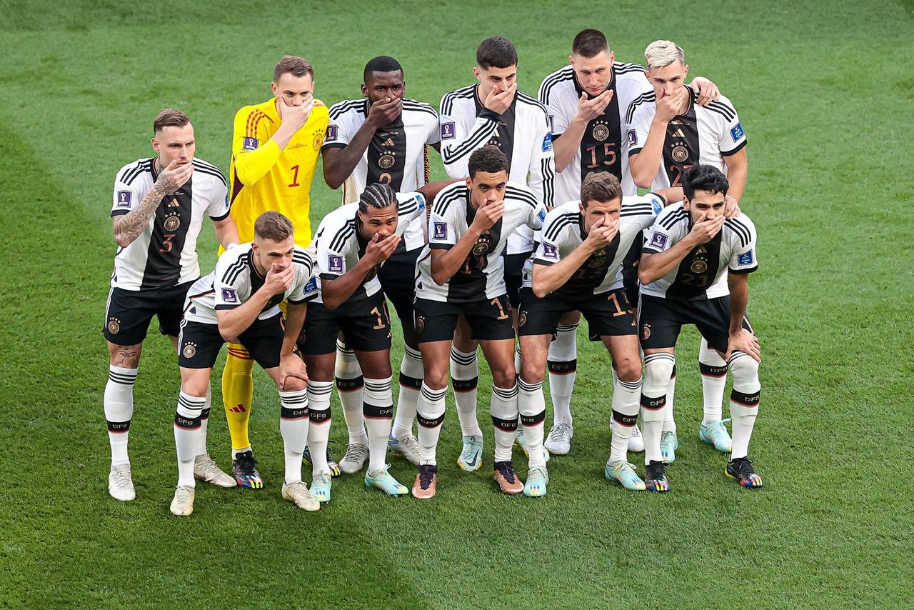 Die Spieler der deutschen Fußballnationalmannschaft stellen sich zum Foto auf und halten sich die Hand vor den Mund.