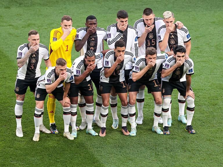 Die Spieler der deutschen Fußballnationalmannschaft stellen sich zum Foto auf und halten sich die Hand vor den Mund.