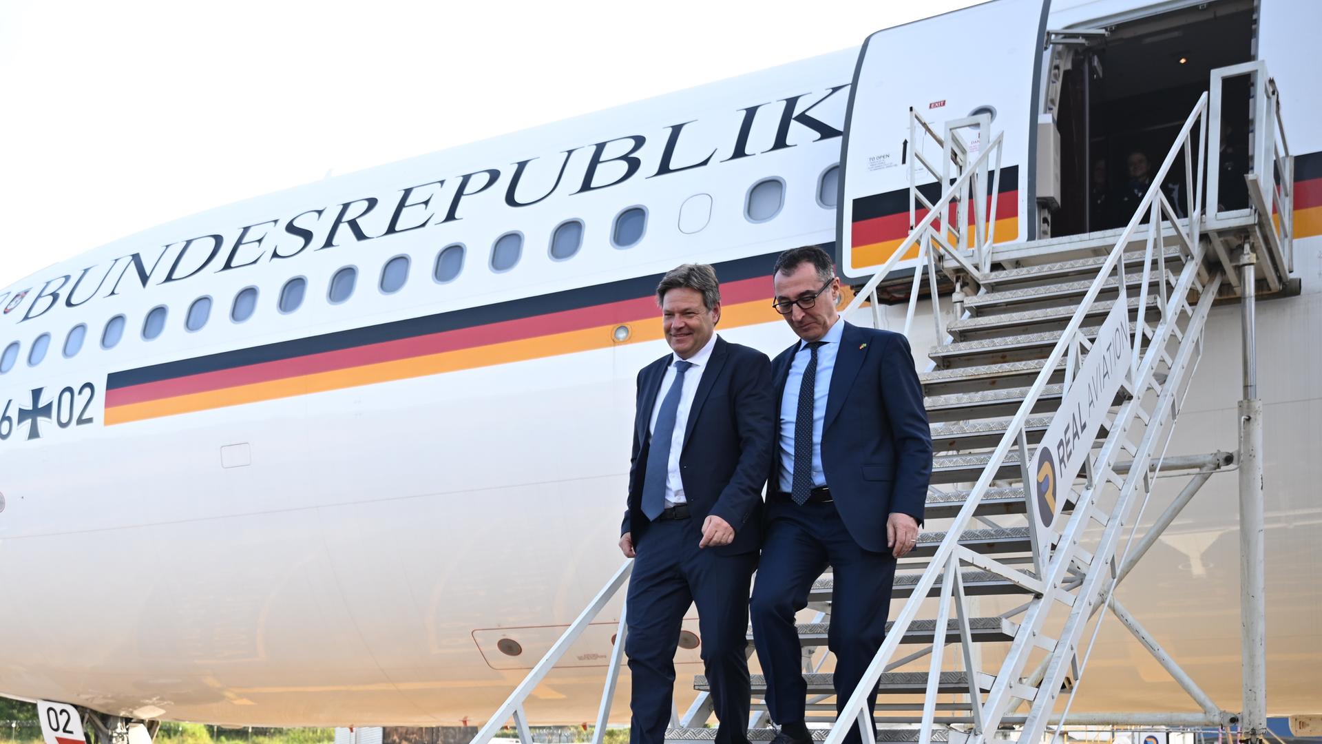 Robert Habeck (rechts) und Cem Özdemir (links) steigen aus einem Flugzeug der Bundesregierung aus. Robert Habeck (rechts) und Cem Özdemir (links) steigen aus einem Flugzeug der Bundesregierung aus.