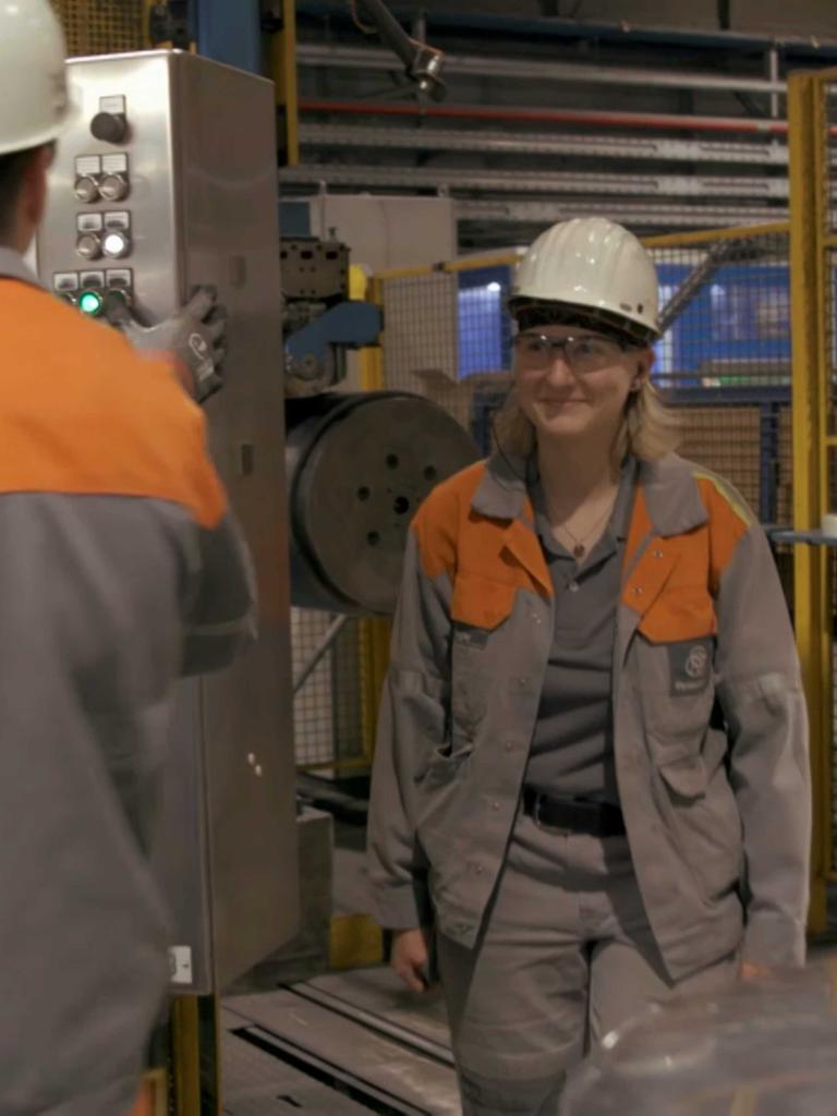 Stahlarbeiterin Lotti im Stahlwerk mit einem anderen Stahlarbeiter.