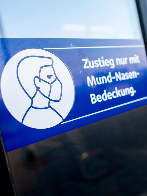 Ein Schild mit der Aufschrift „Zustieg nur mit Mund-Nasen-Bedeckung“ klebt an der Zugtür einer Regio-S-Bahn der NordWestBahn 