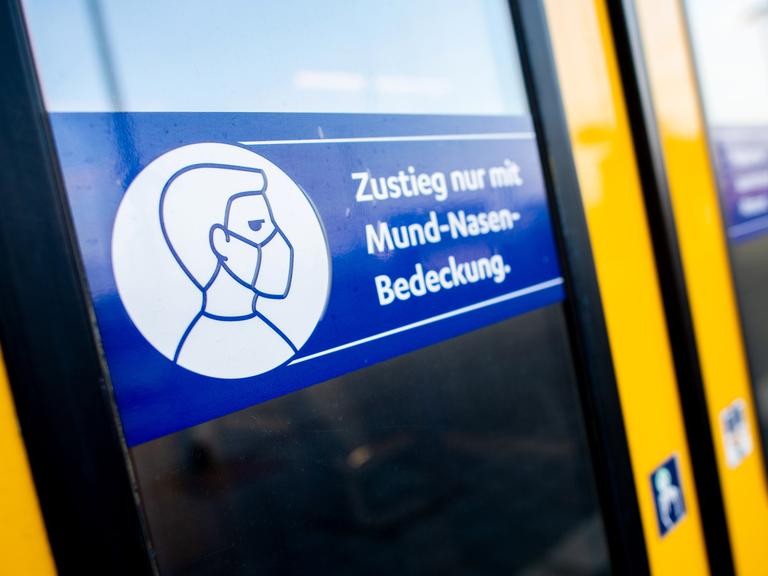 Ein Schild mit der Aufschrift „Zustieg nur mit Mund-Nasen-Bedeckung“ klebt an der Zugtür einer Regio-S-Bahn der NordWestBahn 