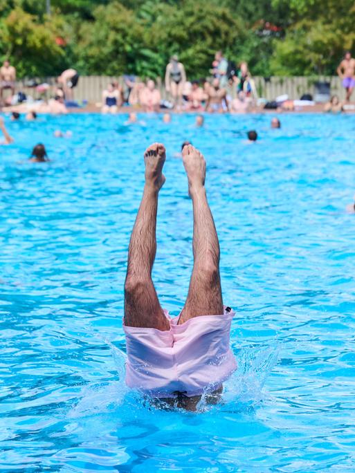 Am ersten Tag der Freibadsaison im Prinzenbad springt ein Schwimmer mit einem Kopfsprung ins Nass.