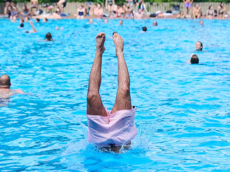 Am ersten Tag der Freibadsaison im Prinzenbad springt ein Schwimmer mit einem Kopfsprung ins Nass.