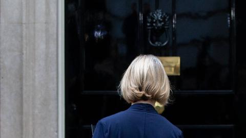 Liz Truss geht am 20. Oktober 2022 nach ihrer Rücktrittsankündigung als britische Premierministerin in Richtung der Tür des Regierungssitzes in Downing Street 10. Sie ist von hinten vor der Tür zu sehen. 