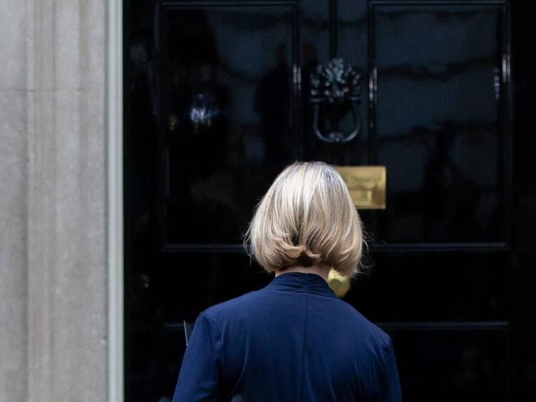 Liz Truss geht am 20. Oktober 2022 nach ihrer Rücktrittsankündigung als britische Premierministerin in Richtung der Tür des Regierungssitzes in Downing Street 10. Sie ist von hinten vor der Tür zu sehen. 