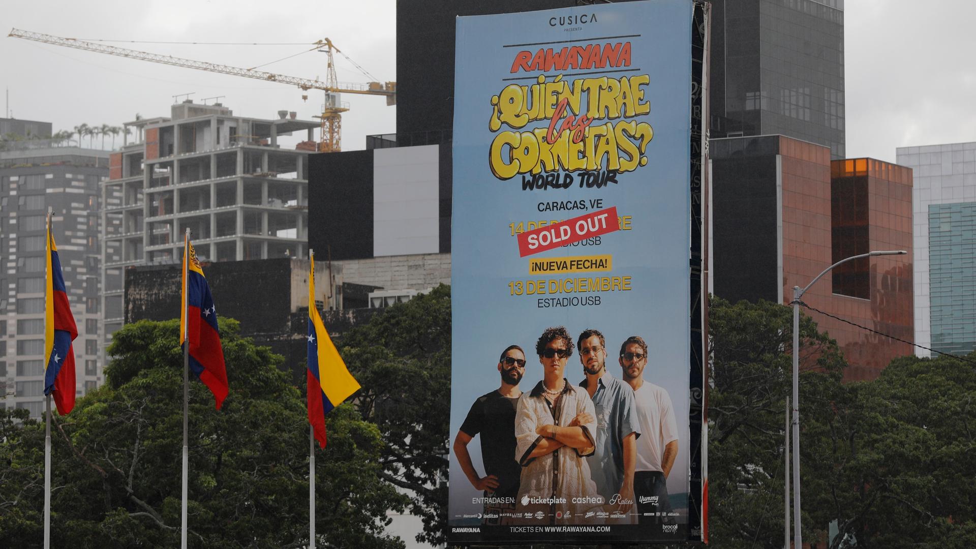 Ein grßes Werbeplakat für das Konzert der Band Rawayana an einem Gebäude in Caracas. Darauf ein rotes Banner mit der Aufschrift "Sold out", also "Ausverkauft"