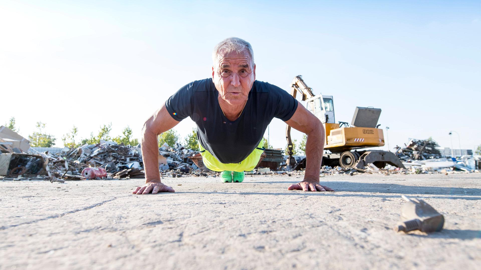 Ein fitter Mann im Seniorenalter macht im Freien Liegestütze. Ein fitter Mann im Seniorenalter macht im Freien Liegestütze.