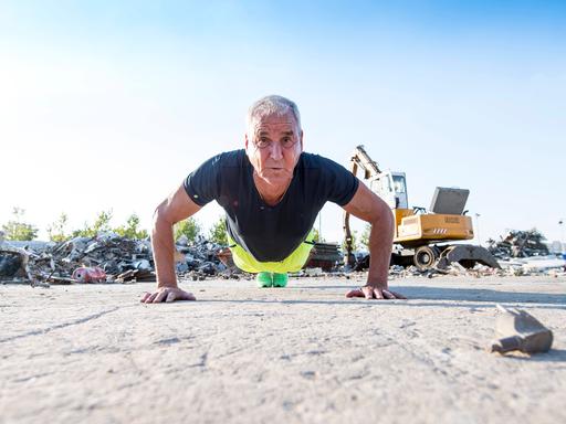Ein fitter Mann im Seniorenalter macht im Freien Liegestütze. Ein fitter Mann im Seniorenalter macht im Freien Liegestütze.