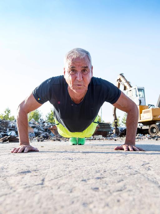 Ein fitter Mann im Seniorenalter macht im Freien Liegestütze. Ein fitter Mann im Seniorenalter macht im Freien Liegestütze.