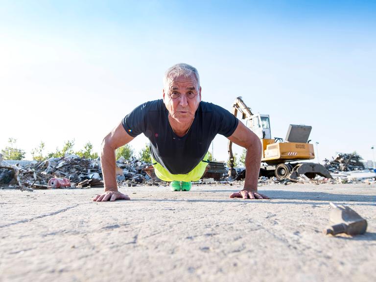 Ein fitter Mann im Seniorenalter macht im Freien Liegestütze. Ein fitter Mann im Seniorenalter macht im Freien Liegestütze.