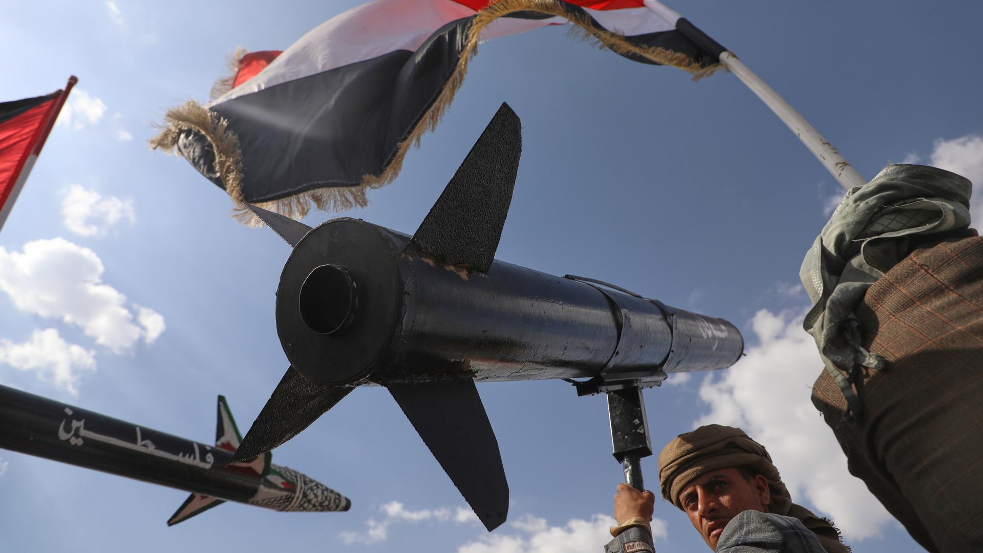 Ein Huthi-Anhänger skandiert Slogans, während er eine Raketennachbildung während einer Anti-US- und Anti-Israel-Kundgebung nach israelischen Luftangriffen in Sanaa trägt.