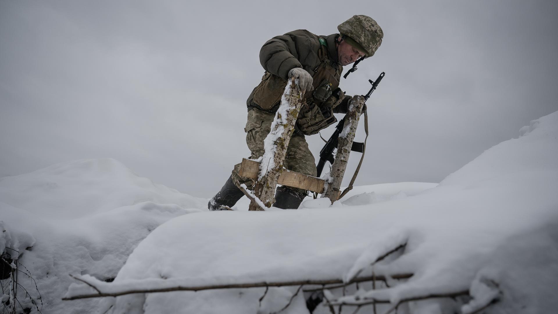 Ein ukrainischer Soldat mitten im Schnee bei Kupiansk.
