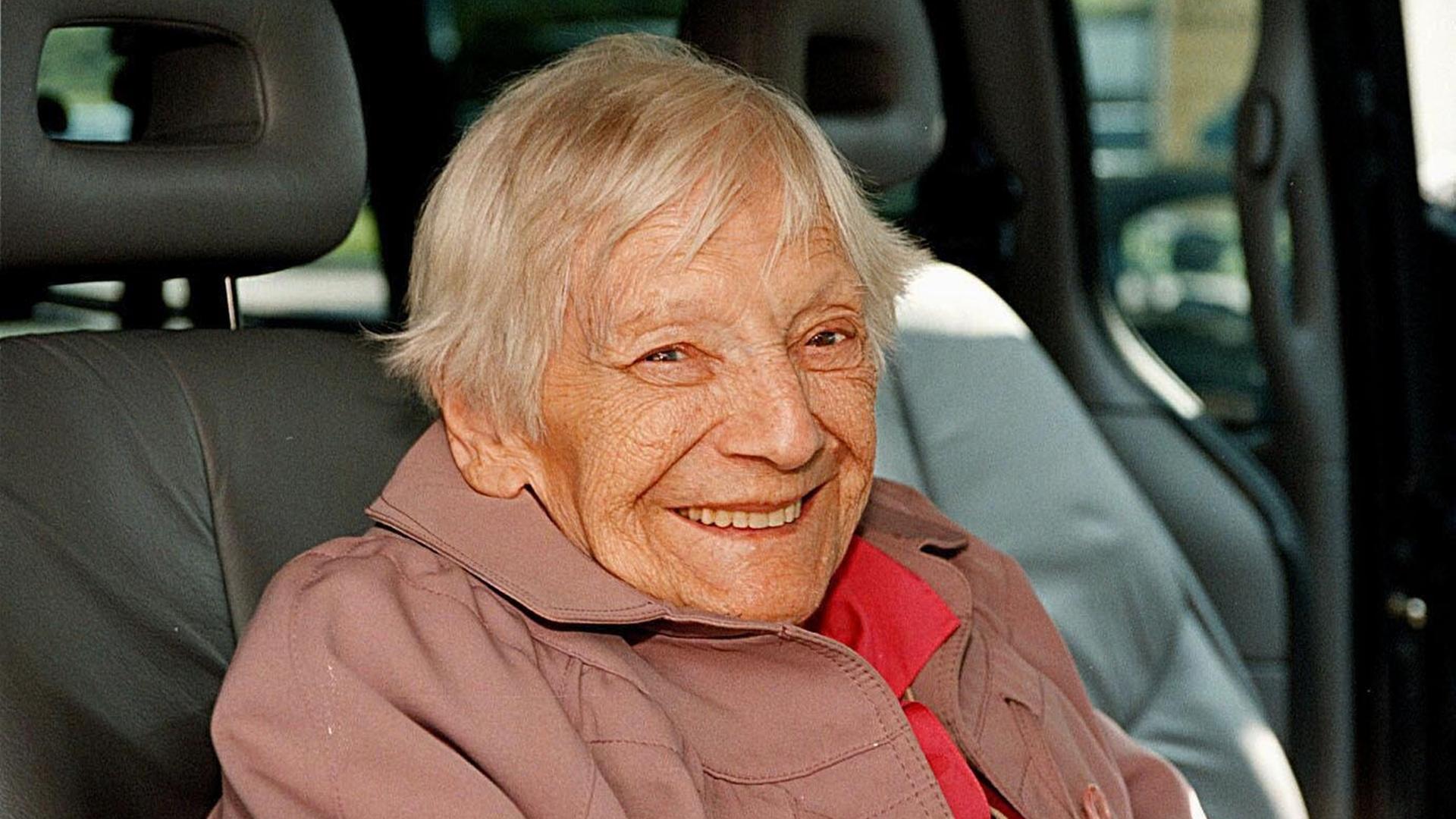 Emilie Schindler sitzt in einem Auto und lächelt in die Kamera