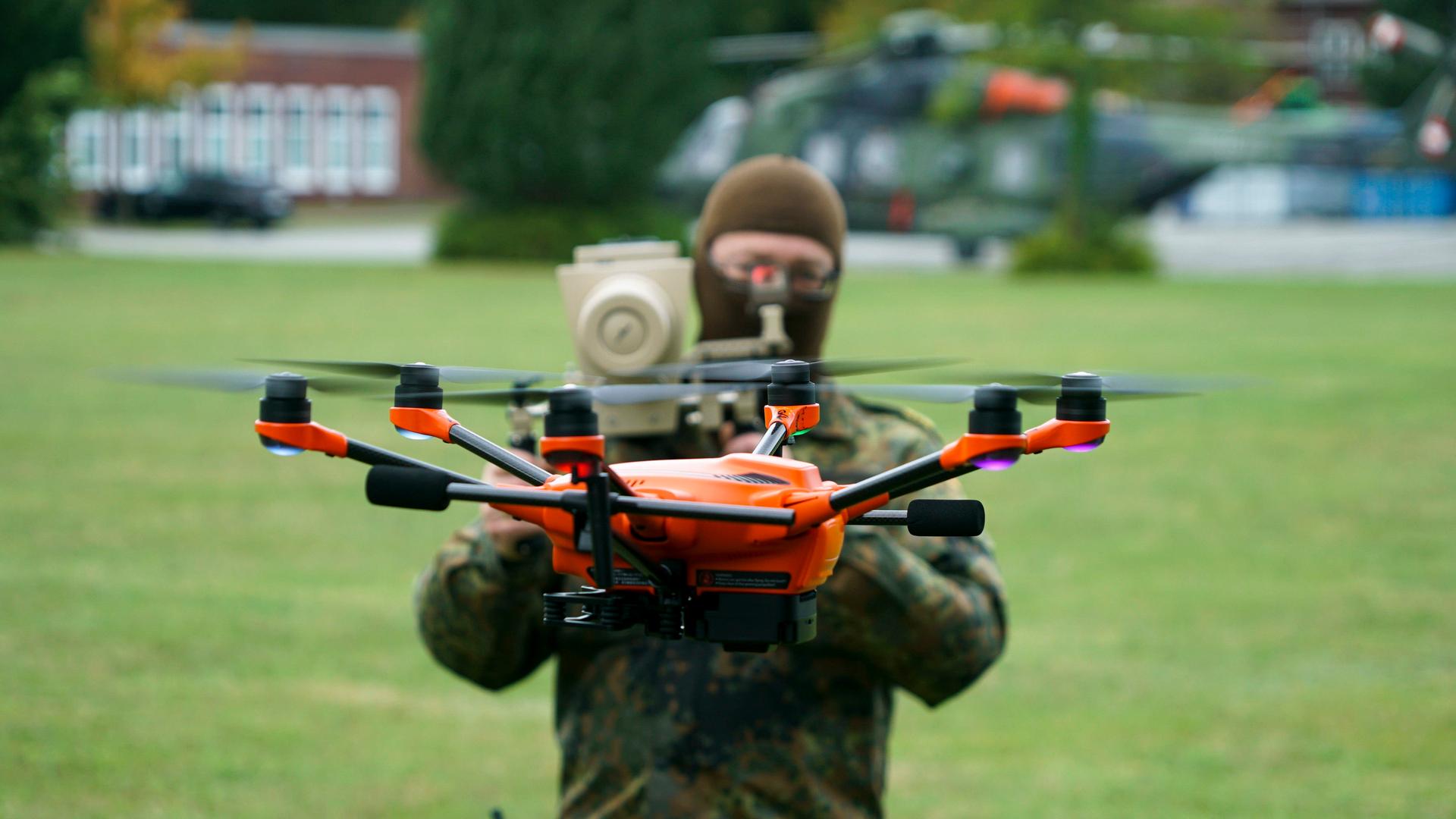 Ein Soldat der Bundeswehr steht hinter einer Drohne