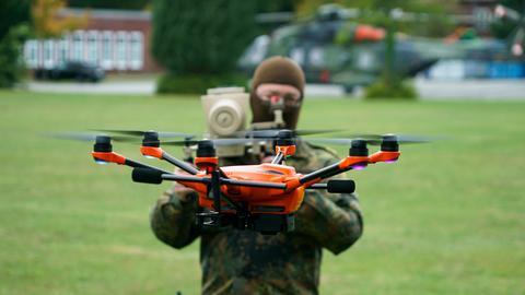 Ein Soldat der deutschen Bundeswehr steht hinter einer Drohne.
