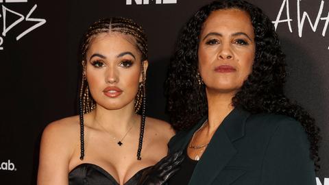 Popstar Mabel und ihre Mutter, Neneh Cherry, stehen vor schwarzem Hintergrund, auf dem oben in weiß die Buchstaben NME stehen. Mabel trägt ein Kleid, ihr Haar hat sie zu vielen kleinen Zöpfen geflochten. 80er-Jahre-Superstar Neneh Cherry trägt ihre langen, schwarzen Haare offen, sie trägt einen Hosenanzug. Beide schauen in die Kamera.  