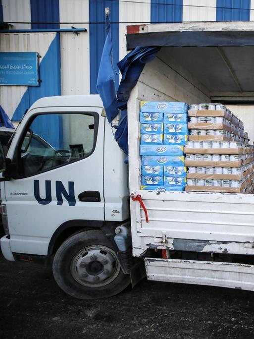 Im November 2023 laden zwei Männer auf einen Lkw der UN Lebensmittel 