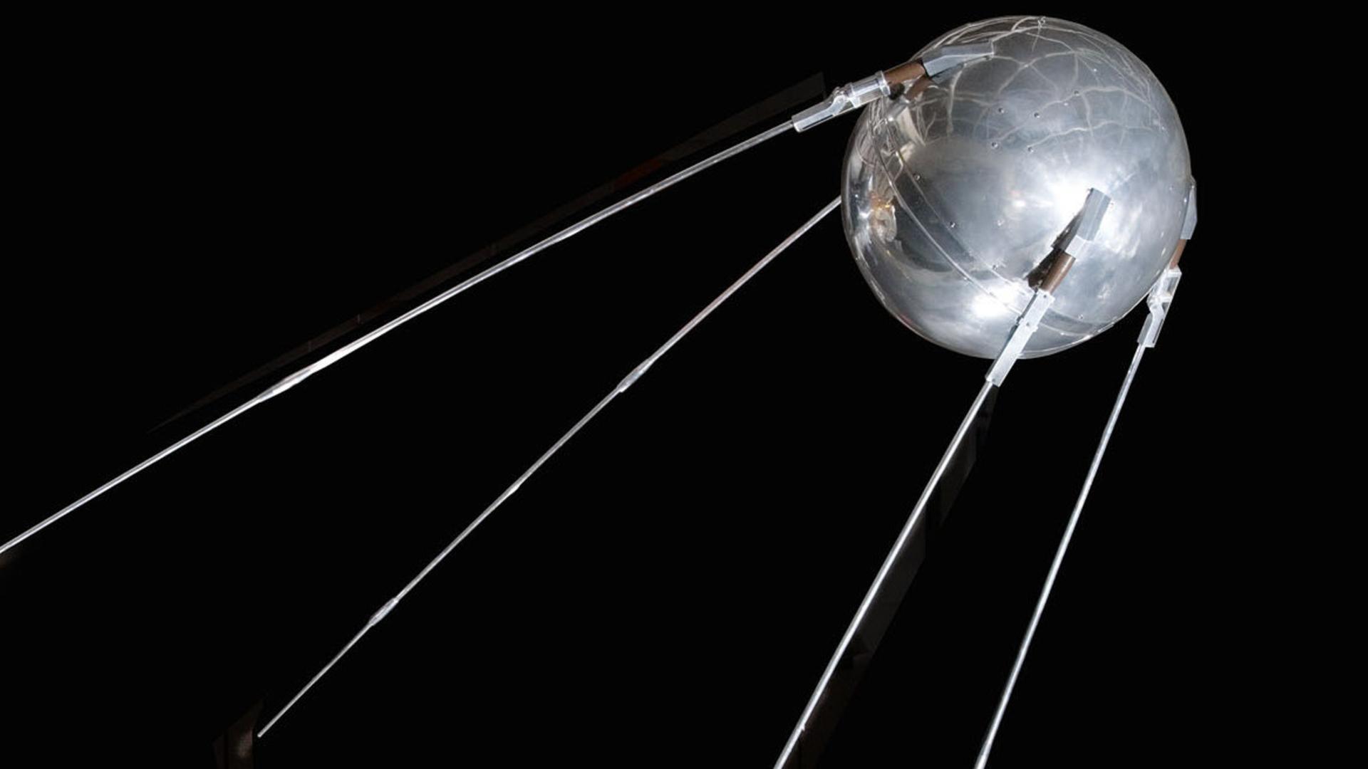 Modell eines Sputnik-Satelliten vor einem dunklen Hintergrund. Modell eines Sputnik-Satelliten vor einem dunklen Hintergrund.