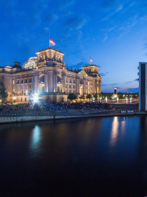 Panorama des Berliner Reichstags neben dem Deutschen Bundestag bei Nacht.