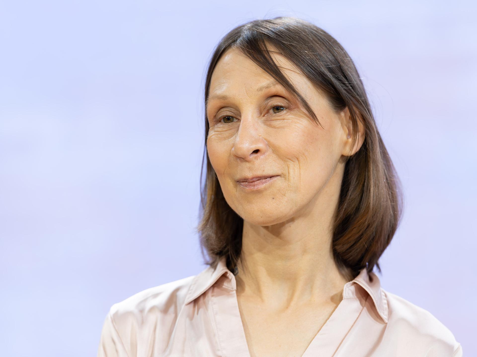 Die Schriftstellerin Martina Hefter im Porträt vor hellblauem Hintergrund 
