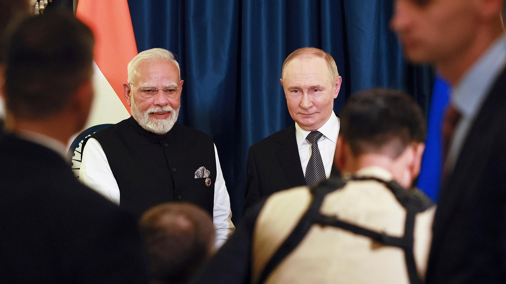 Putin und Modi sitzen nebeneinander, vor ihnen verschwommen einige Reporter. Putin und Modi sitzen nebeneinander, vor ihnen verschwommen einige Reporter.
