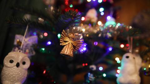 Ein goldener Engel und eine Eule in Nahaufnahme am Weihnachtsbaum hängend