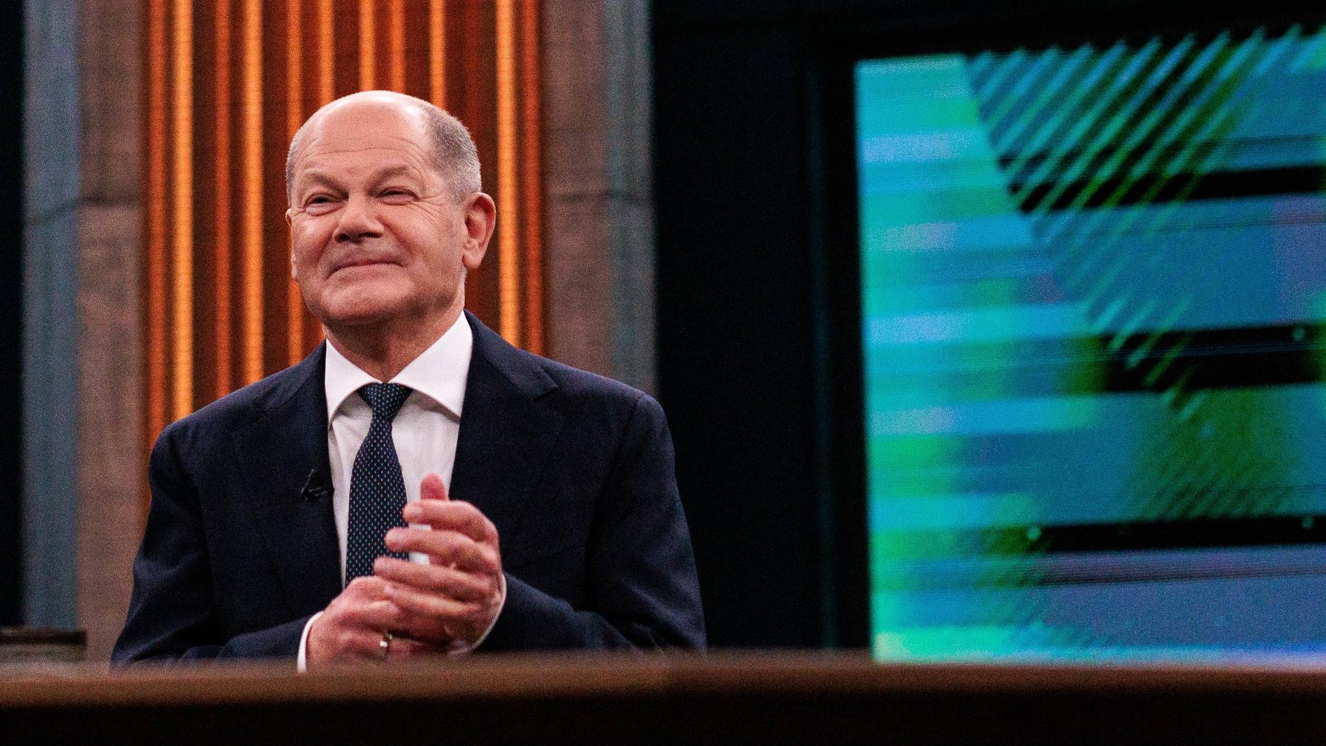 Bundeskanzler Olaf Scholz (SPD) sitzt im Fernsehstudio der ARD-Sendung "Caren Miosga". 