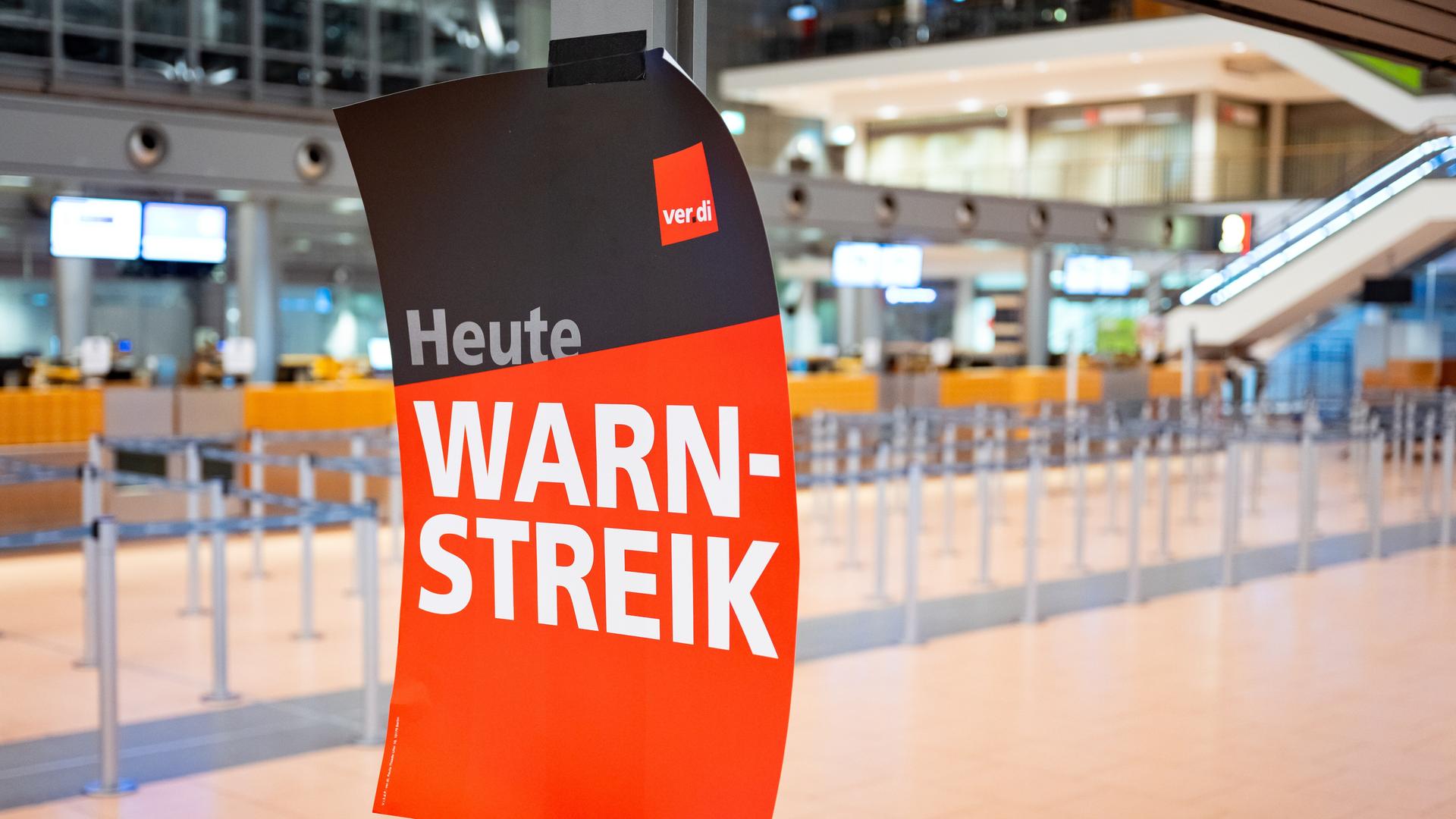 "Heute Warnstreik" steht auf einem verdi-Plakat an einem Flughafen. 