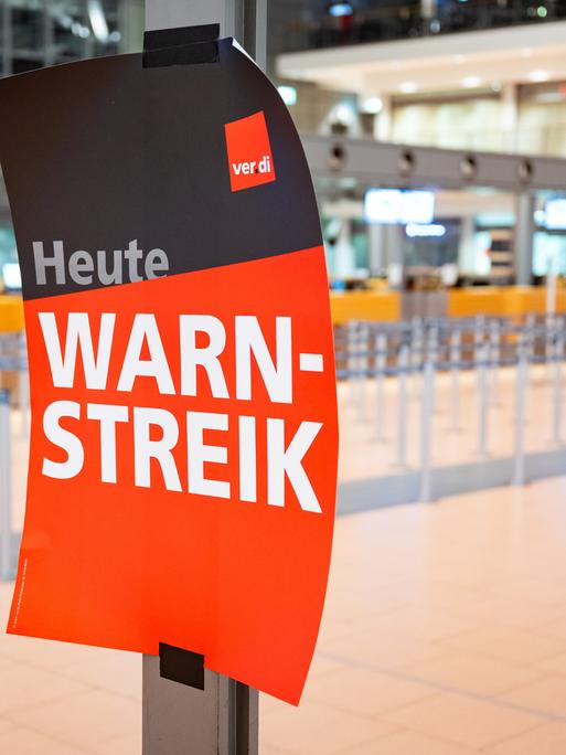 "Heute Warnstreik" steht auf einem Verdi-Plakat an einem Flughafen. 