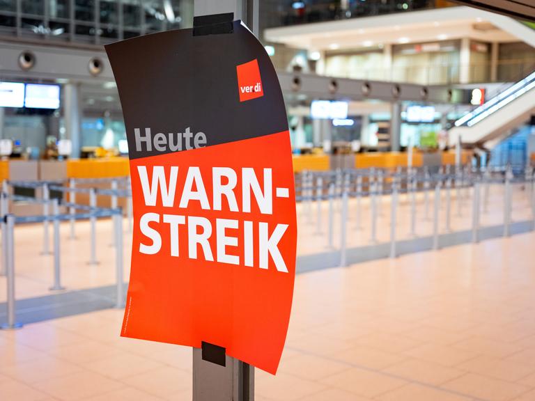 "Heute Warnstreik" steht auf einem Verdi-Plakat an einem Flughafen. 