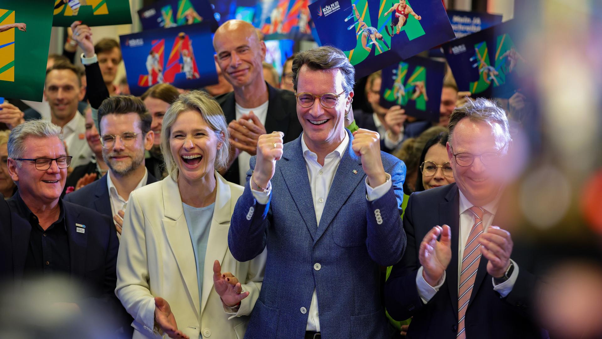 Hendrik Wüst (CDU, Mitte), Ministerpräsident des Landes Nordrhein-Westfalen, jubelt nach der erfolgreichen Abstimmung um die Olympischen Spiele in Nordrhein-Westfalen.