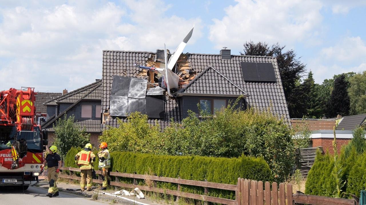 Ein abgestürztes Leichtflugzeug steckt im Dach eines Hauses. Ein abgestürztes Leichtflugzeug steckt im Dach eines Hauses.