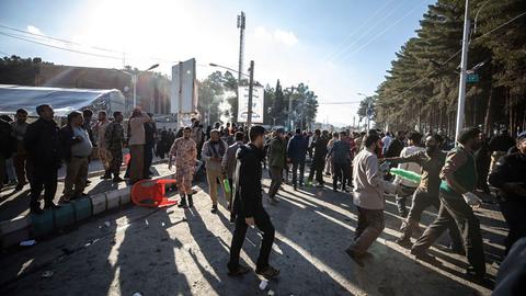 Iran, Kerman: Menschen versammeln sich nach Explosionen auf einer Straße.