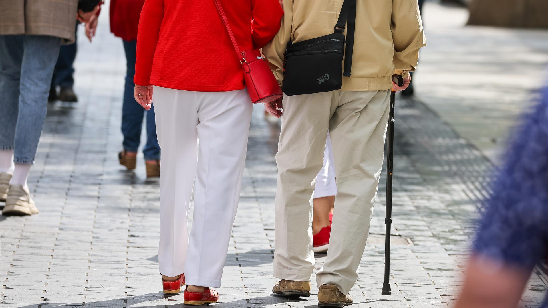 Ein Seniorenpaar geht durch die Leipziger Innenstadt.