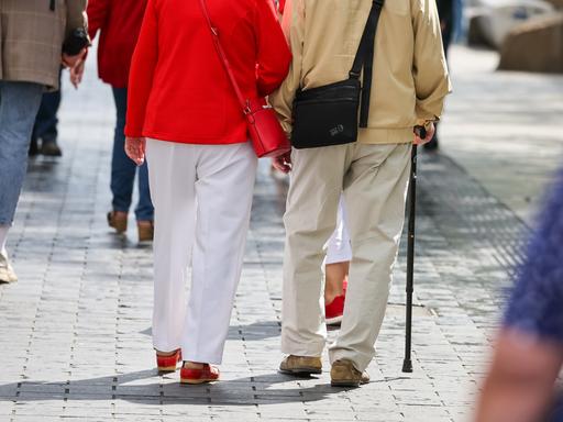 Ein Seniorenpaar geht durch die Leipziger Innenstadt.
