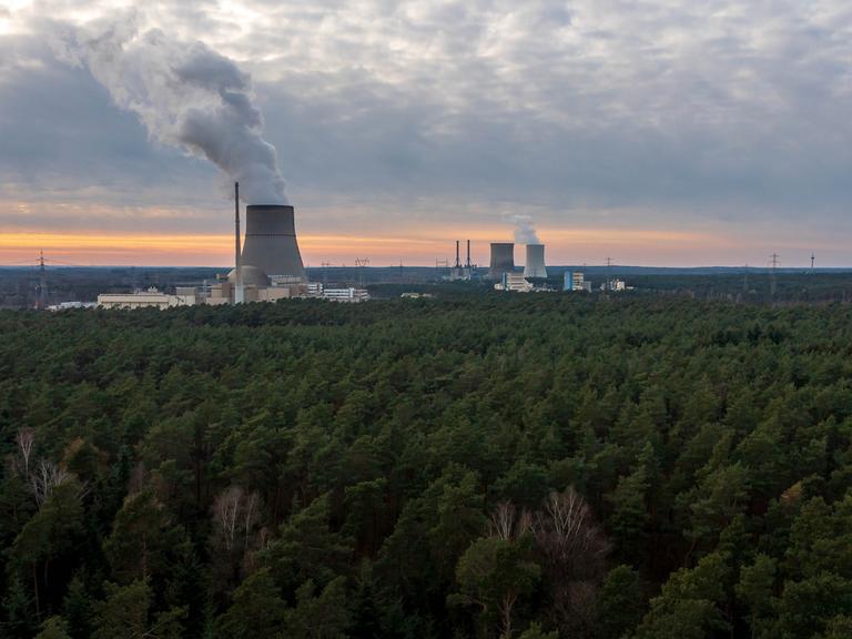 Das Atomkraftwerk Emslandmitten im Waldgebiet mit rauchendem Schornstein. 