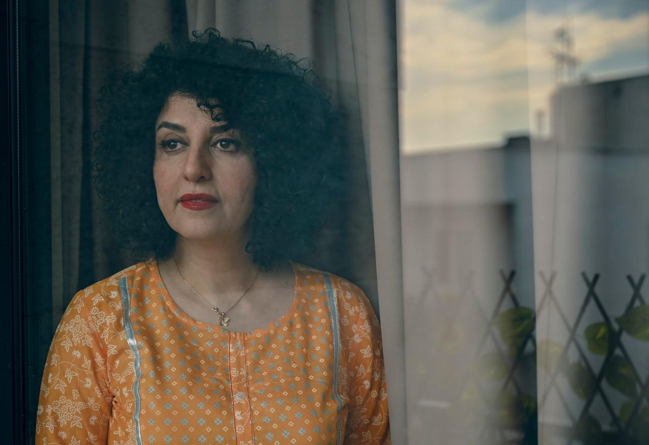 Die Friedensnobelpreisträgerin Narges Mohammadi steht mit gelber Bluse vor einem Fenster.