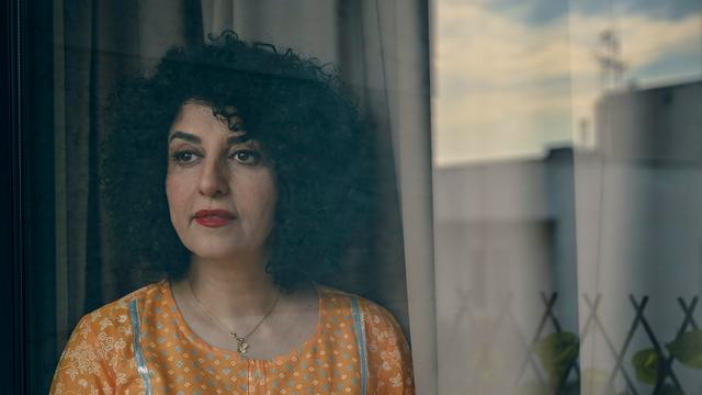Narges Mohammadi steht mit gelber Bluse vor einem Fenster.