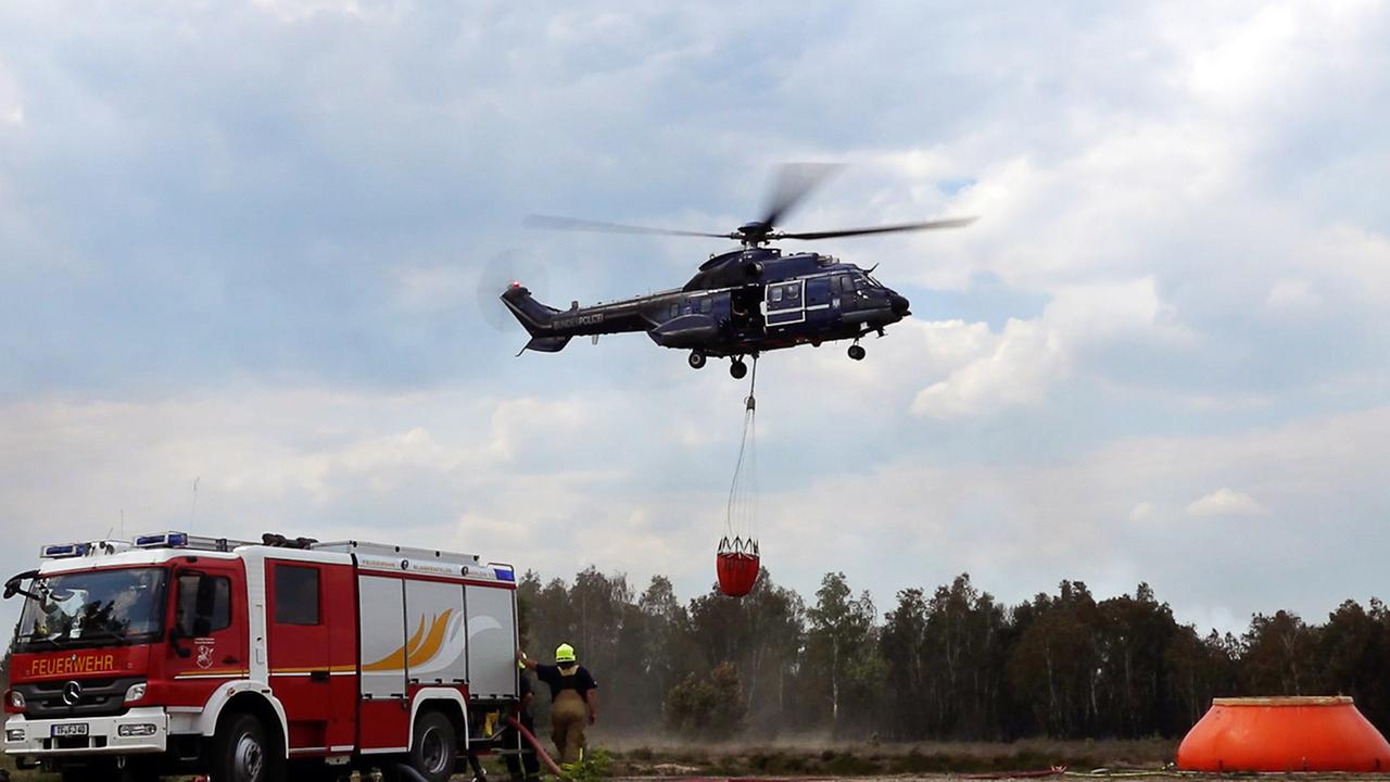 Ein Hubschrauber steigt auf. Er bringt einen Sack mit Wasser zu einem Waldstück nahe Jüterbog.