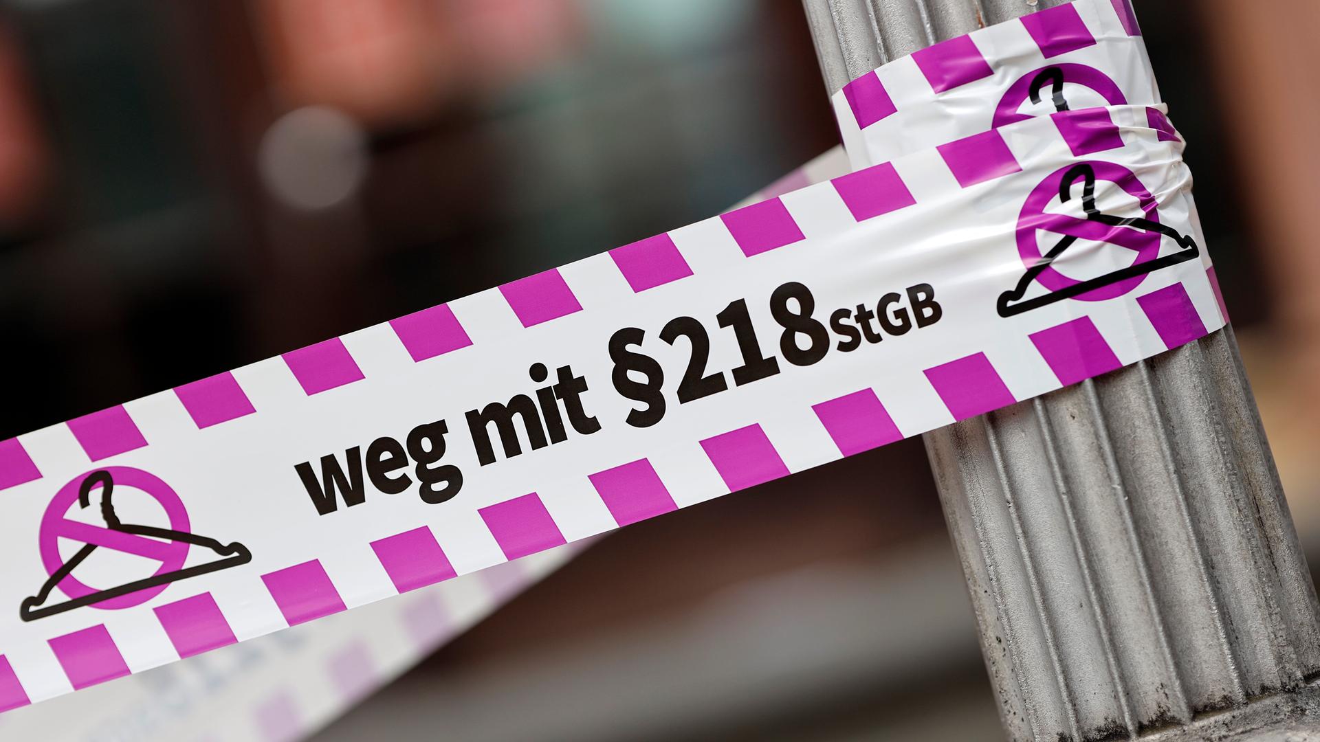 Nahaufnahme eines Flatterbandes mit dem Slogan "Weg mit Paragraf 218" bei einer Pro-Abtreibungs-Demo