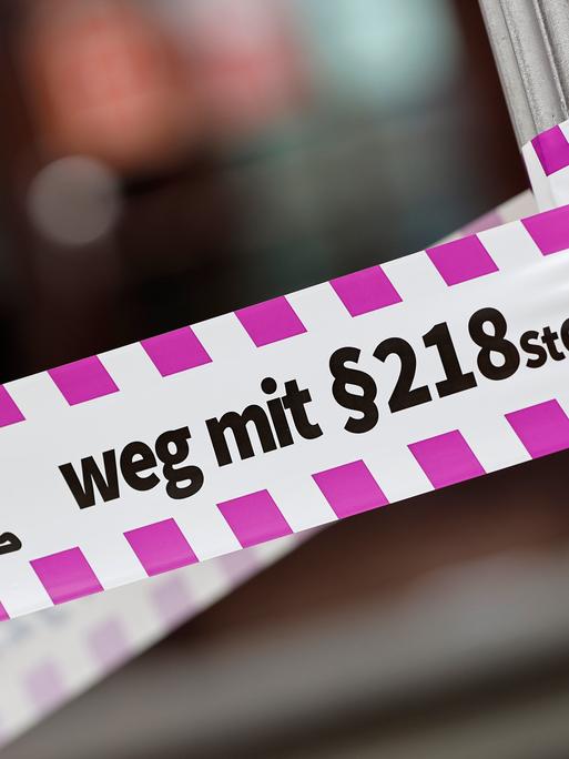 Nahaufnahme eines Flatterbandes mit dem Slogan "Weg mit Paragraf 218" bei einer Pro-Abtreibungs-Demo