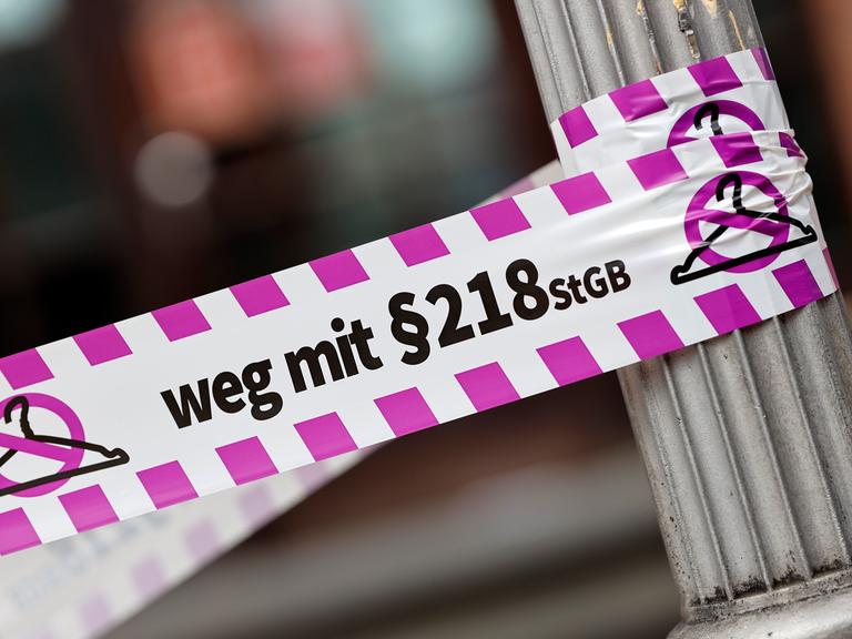 Nahaufnahme eines Flatterbandes mit dem Slogan "Weg mit Paragraf 218" bei einer Pro-Abtreibungs-Demo