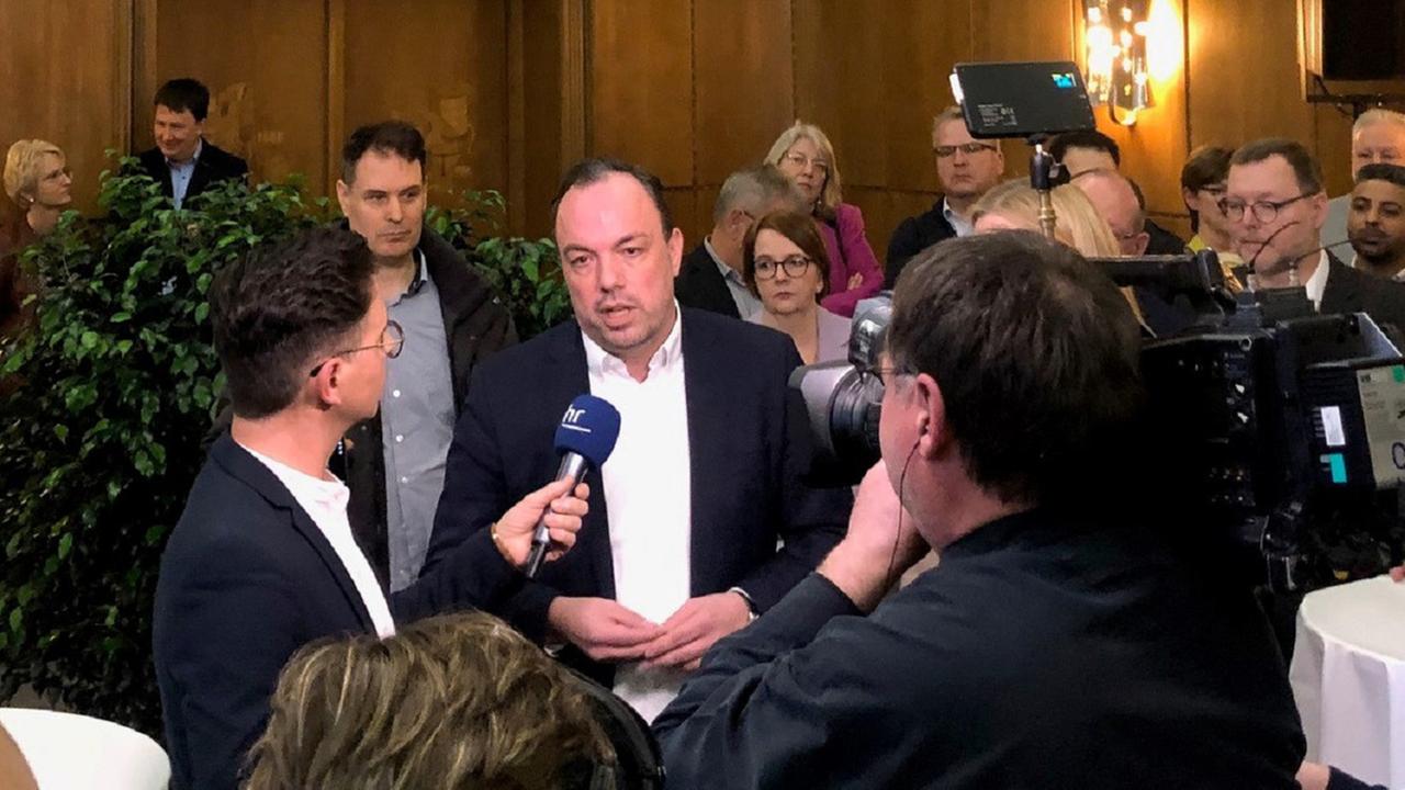 Der Kasseler Oberbürgermeister Christian Geselle (Mitte) steht im Kasseler Rathaus vor Journalisten und gibt ein Interview.