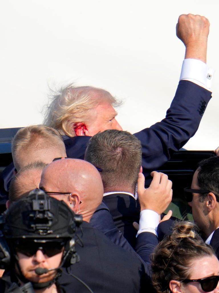 Der republikanische Präsidentschaftskandidat und ehemalige US-Präsident Donald Trump reckt seine Faust in die Höhe, als er nach einem Anschlag auf ihn von Sicherheitsleuten in ein Auto gebracht wird.