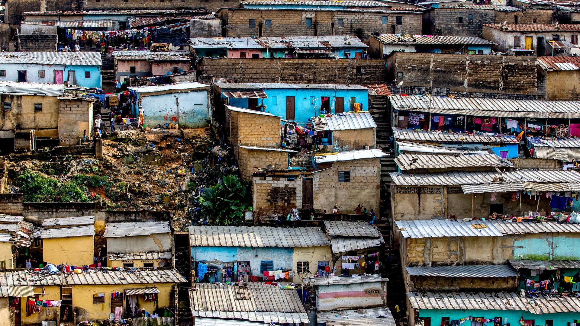 Vogelperspektive auf die bunten Häuser eines Slums in Abidjan in Elfenbeinküste