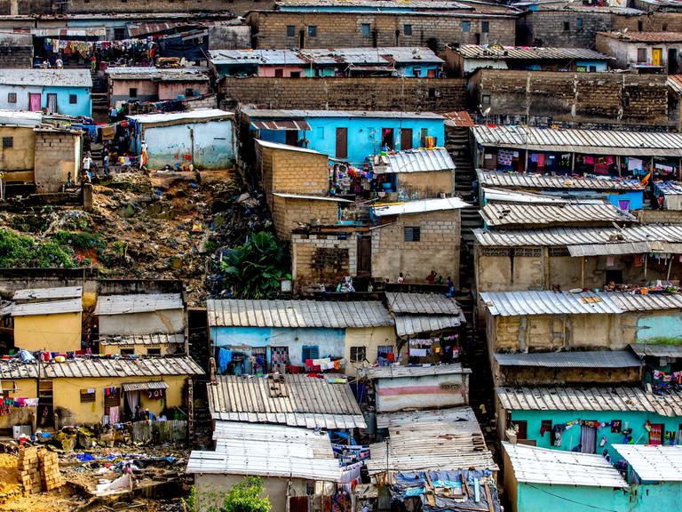 Vogelperspektive auf die bunten Häuser eines Slums in Abidjan in Elfenbeinküste