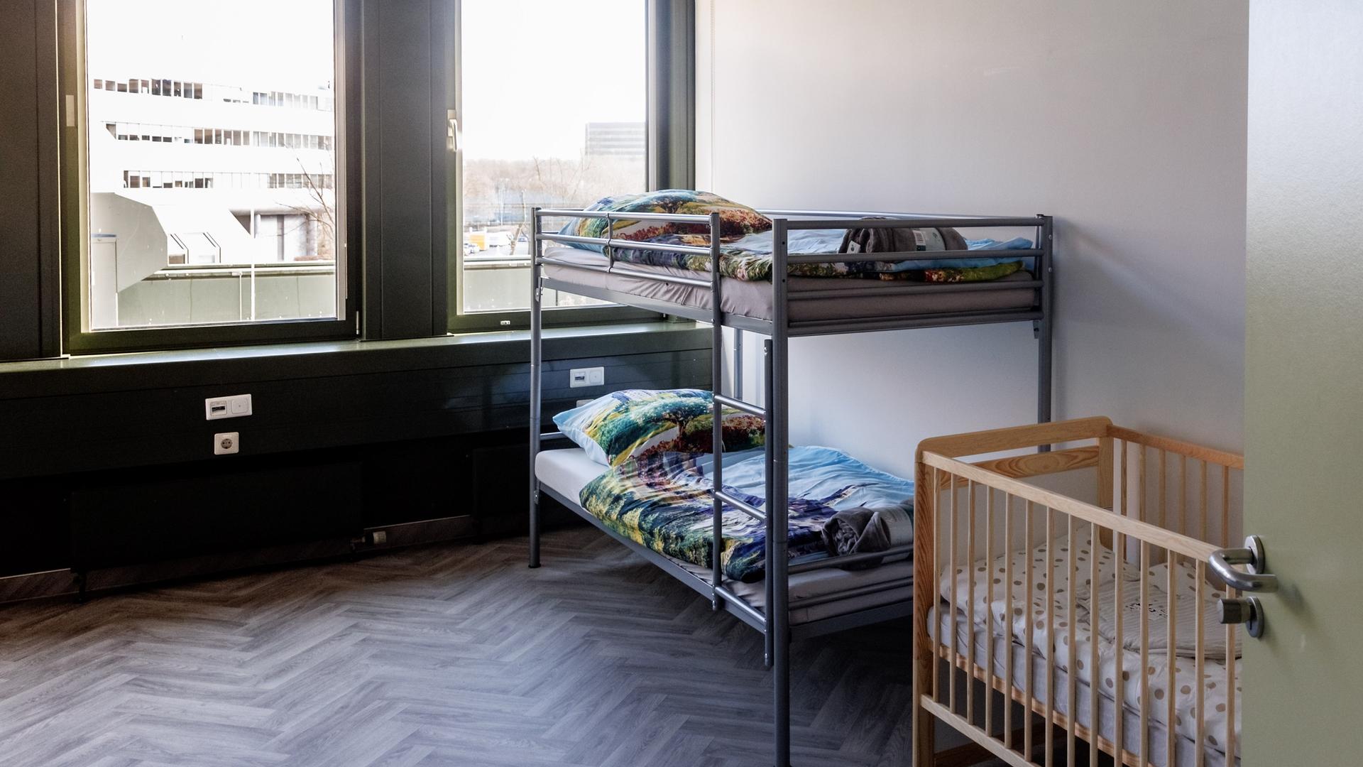Blick in einen für Flüchtlinge eingerichteten Wohnraum mit einem Stockbett und einem Kinderbett.