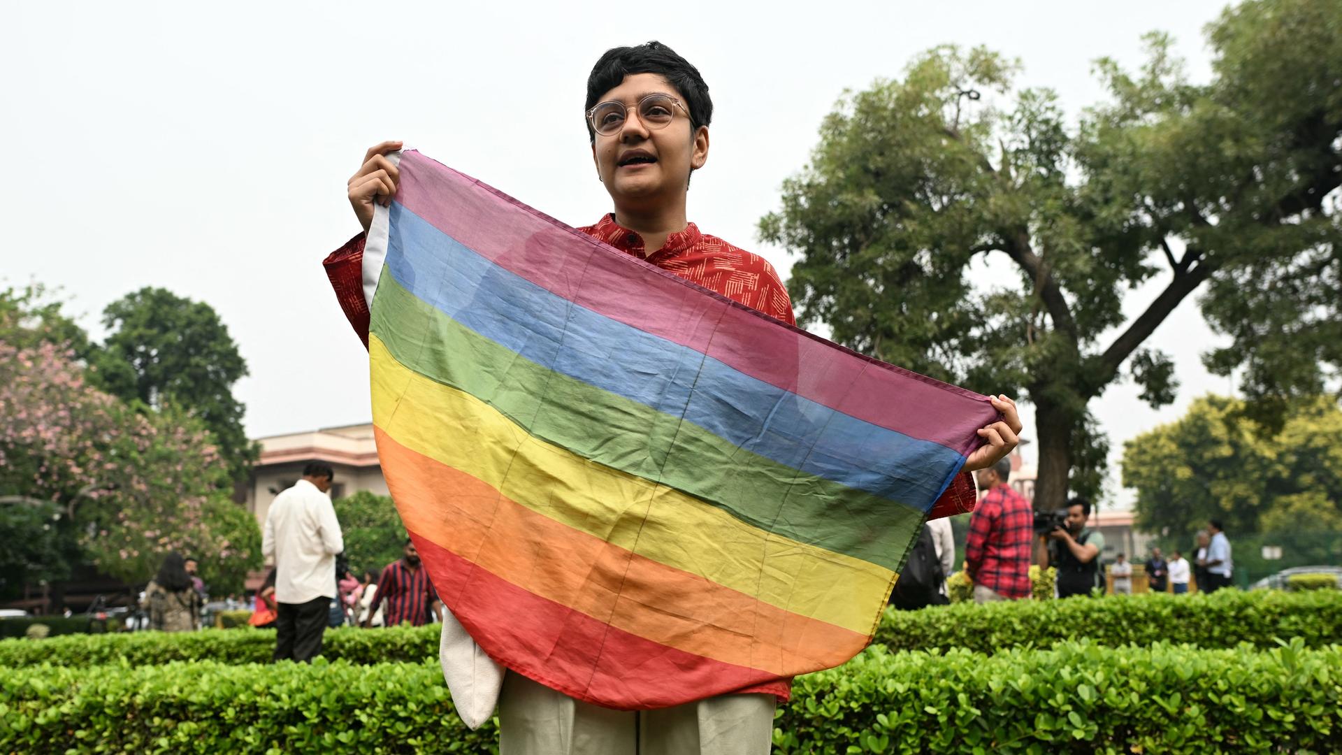Ein Aktivist hält eine Regenbogenfahne vor sich. Er demonstriert vor dem Obersten Gericht in Neu-Delhi.